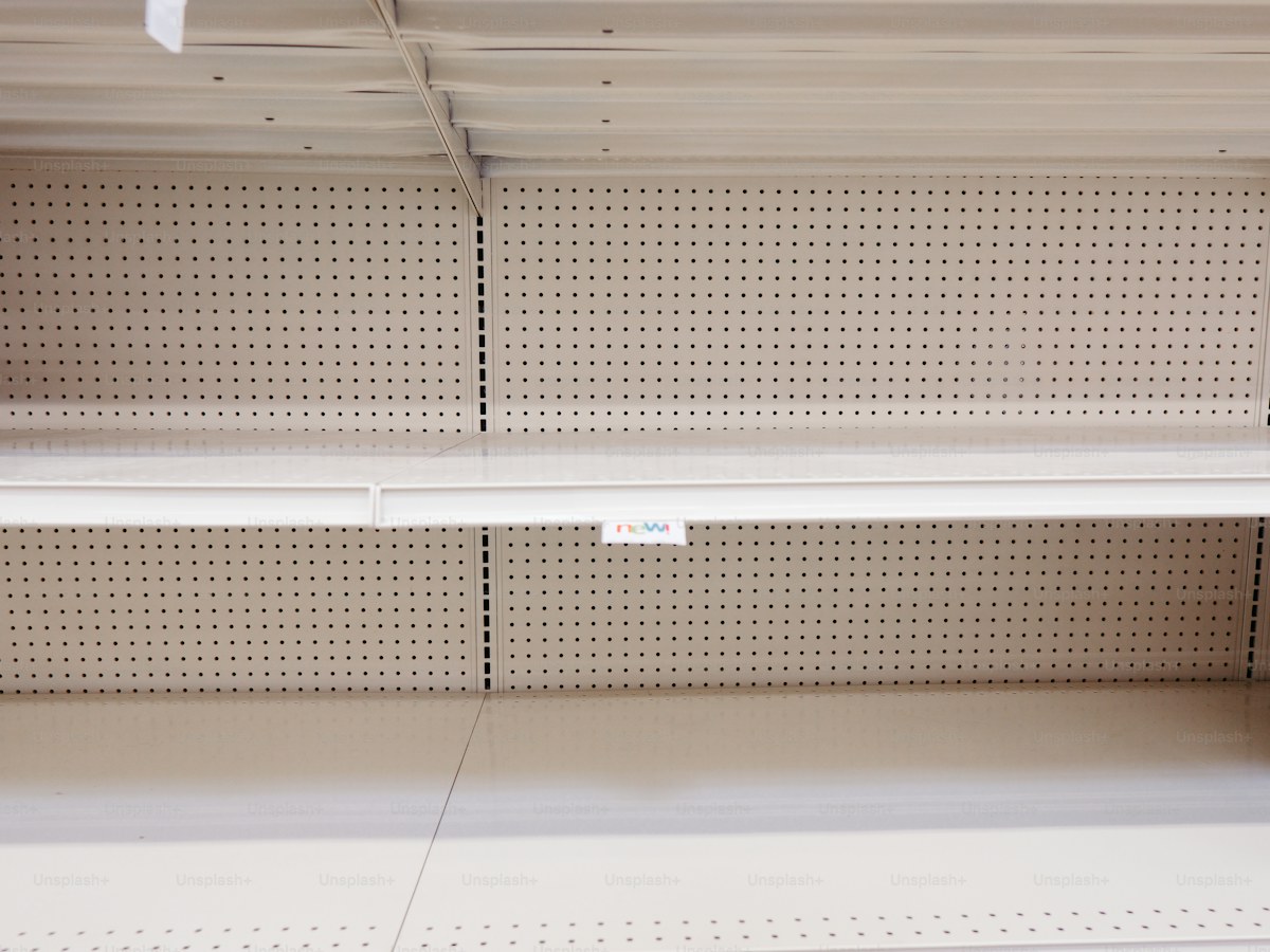 a empty shelf in a store with a price tag